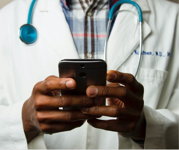 A telemedicine doctor chatting with his medical team on a phone app